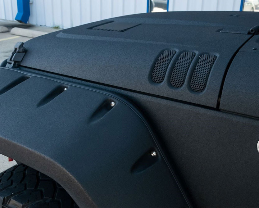 Black Jeep with textured bedliner coating on the hood and fenders